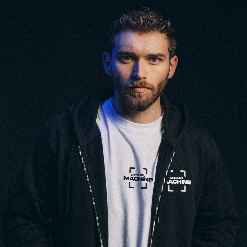 Mannequin homme portant le Hoodie Basics 2.0 noir zippé, vue de face, avec sérigraphie côté cœur et transfert au bras droit, coupe oversize