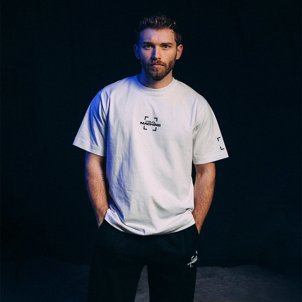 Mannequin homme portant le T-shirt blanc Basics 2.0 en coton biologique et coupe oversize, assorti au Jogging Basics 2.0 noir, sérigraphie côté cœur