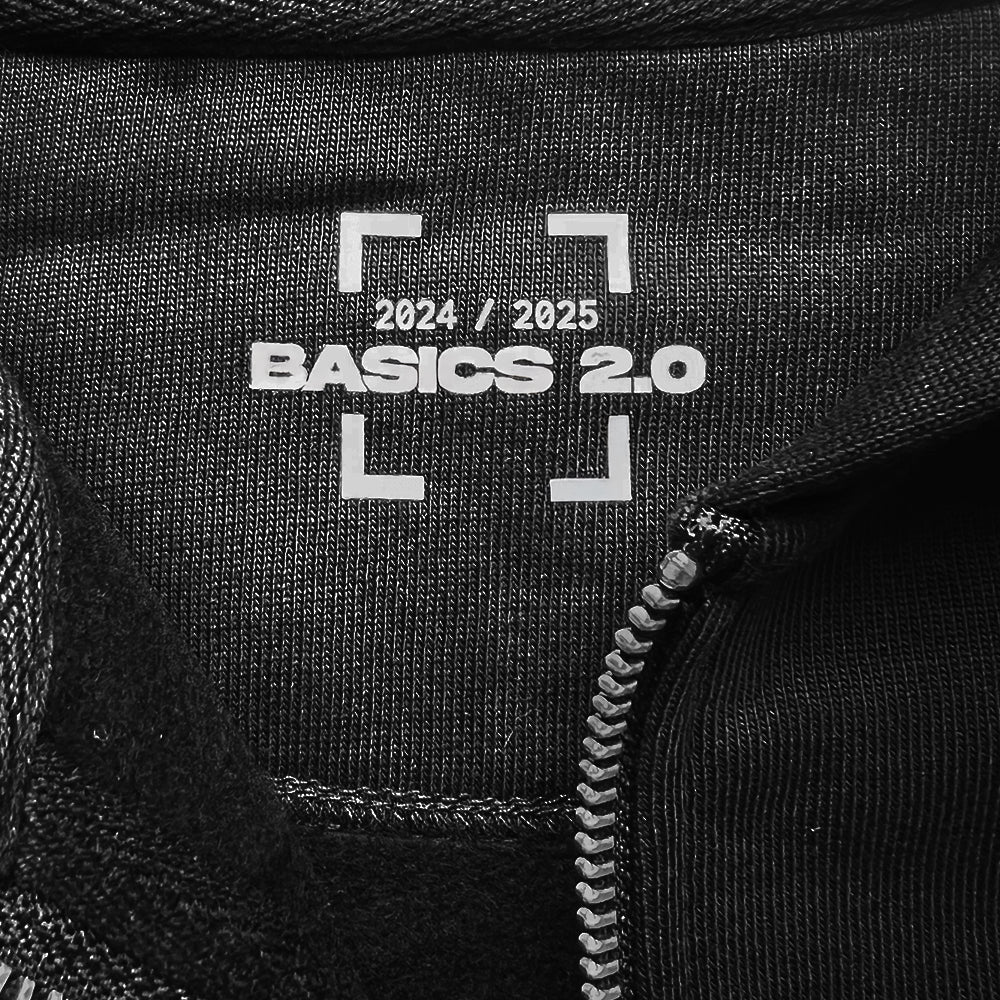 Zoom sur le transfert au col du Hoodie Basics 2.0 noir zippé, montrant les détails précis du marquage sérigraphié, certifié Oeko-Tex et GOTS