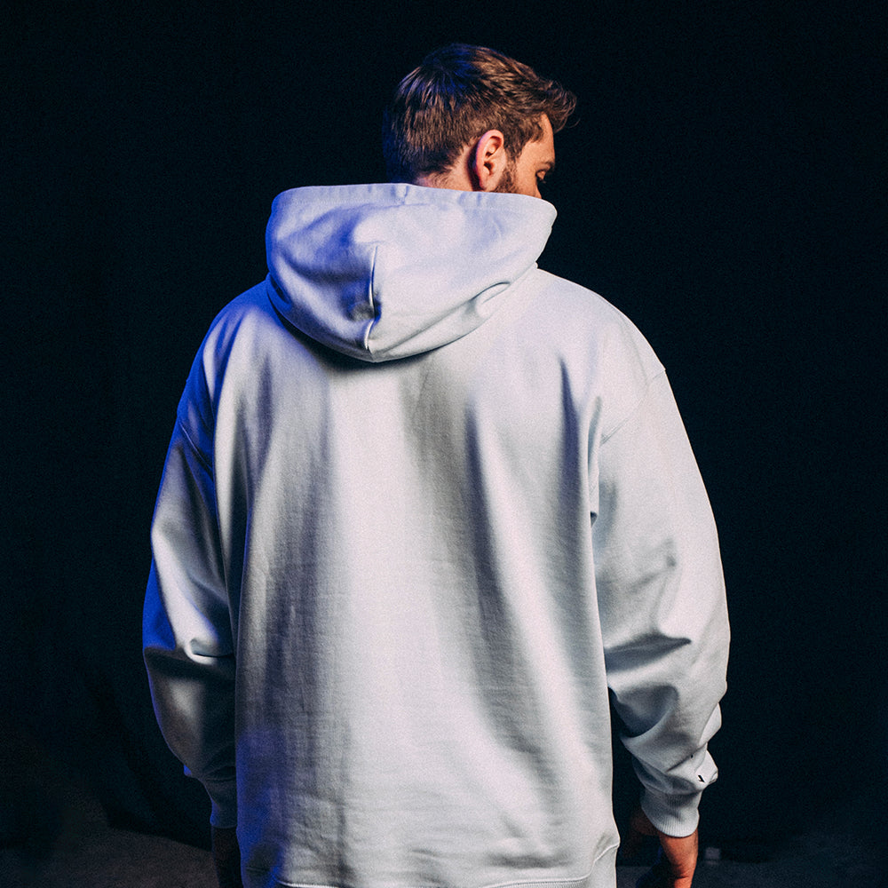 Vue arrière du hoodie Basics 2.0, coupe oversize, coloris bleu clair, modèle unisexe