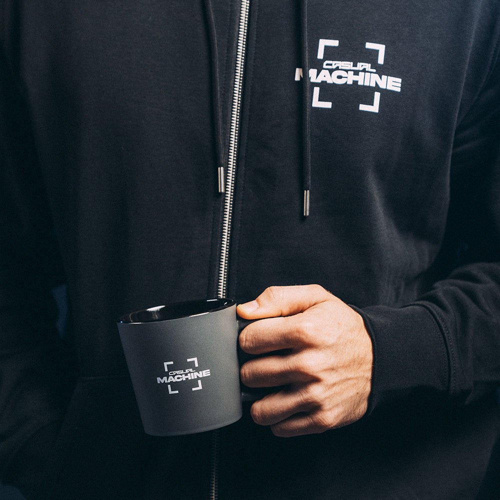 Personne tenant un Mug gris 370 ml en céramique finition mate, sérigraphie logo sur la face avant, avec la veste Basics 2.0