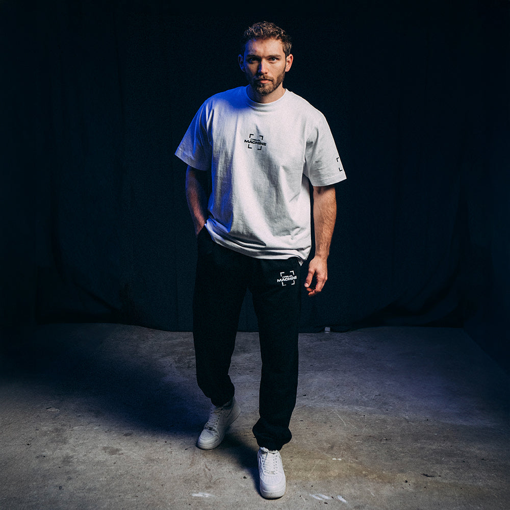 Homme portant le Jogging Basics 2.0 noir avec un t-shirt blanc, tenue unisexe et décontractée, coton organique 400 g