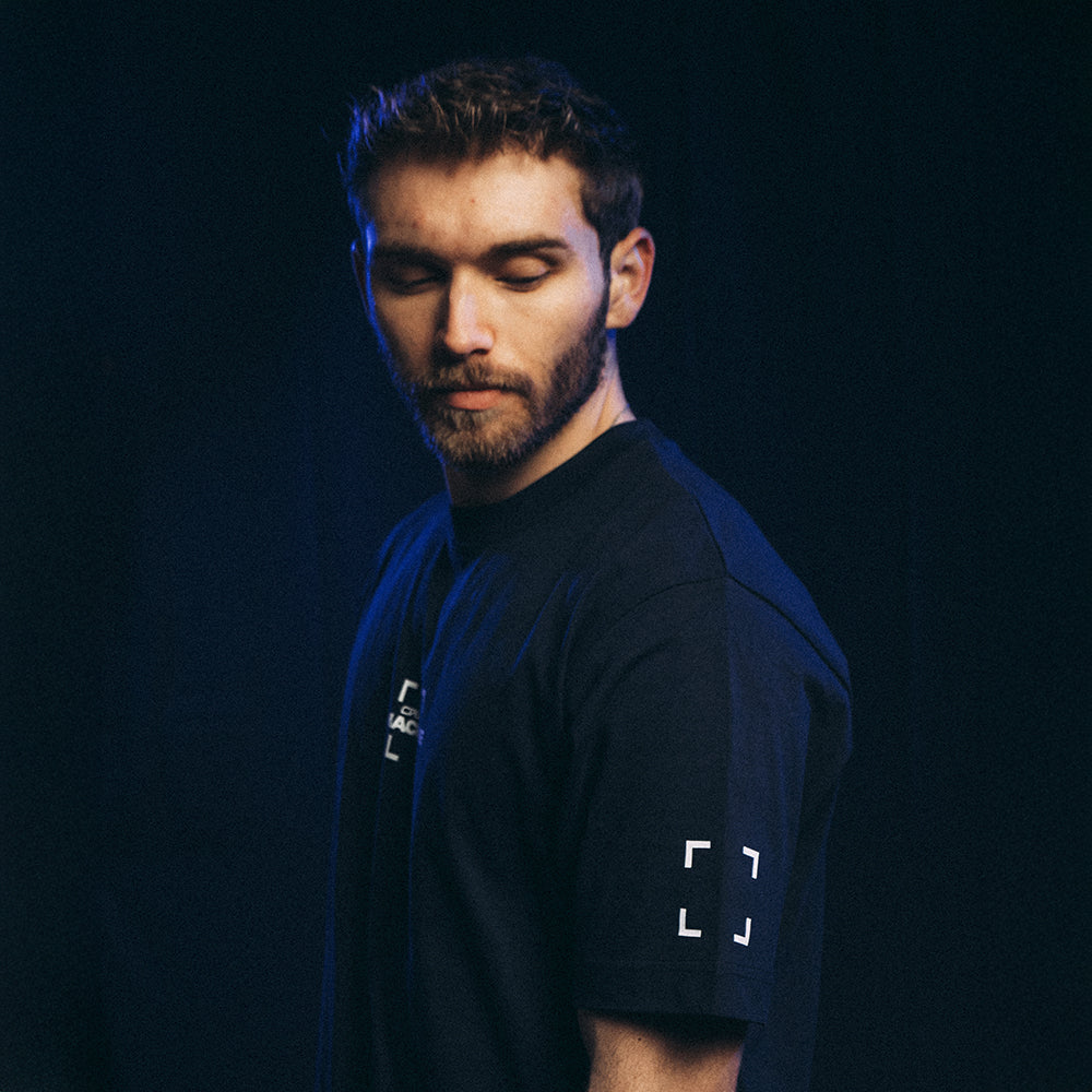 Mannequin homme de profil portant le T-shirt blue Basics 2.0 coupe oversize en coton biologique, avec sérigraphie côté cœur et sur le col