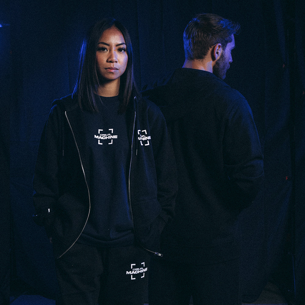 Duo de mannequins portant le Hoodie Basics 2.0 noir zippé : femme de face avec le T-shirt blue Basics 2.0 visible et homme de dos mettant en valeur la coupe oversize